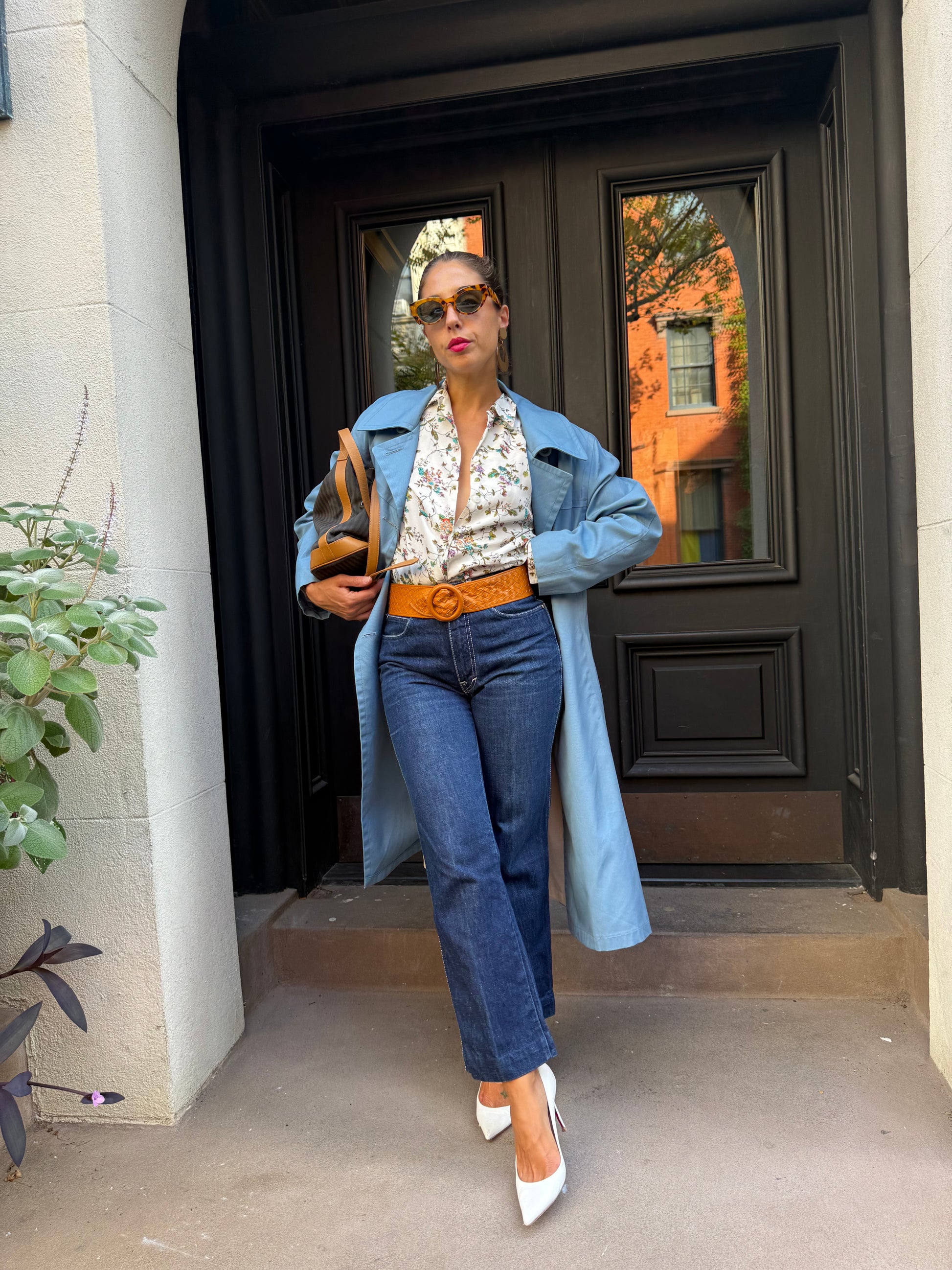Person standing in front of a black fireplace with a mirror, wearing a blue jacket and jeans.